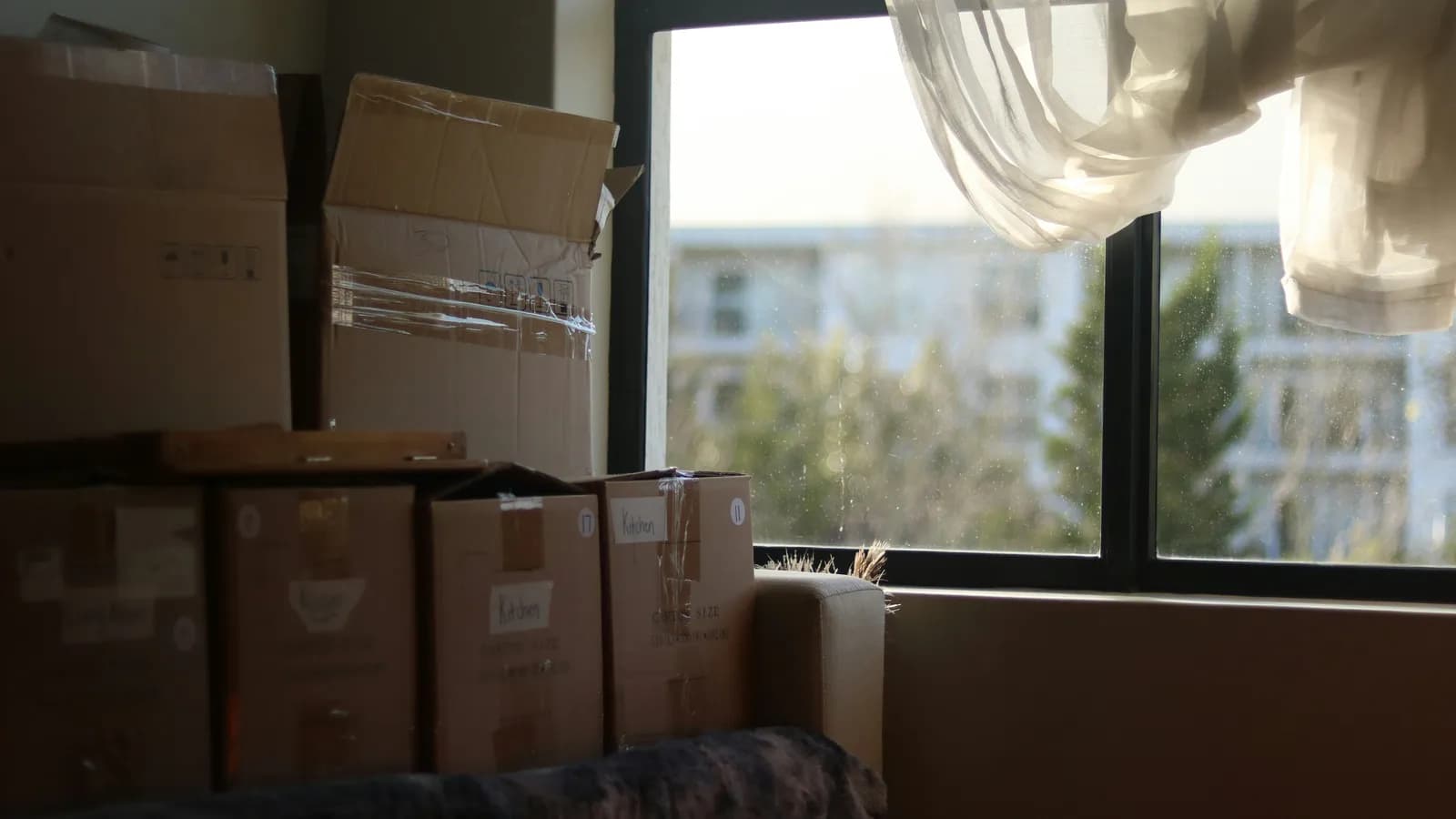 Cartons de déménagement empilés près d'une fenêtre dans un appartement